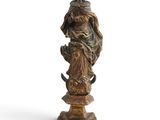 an old statue of a woman holding a cat on a pedestal