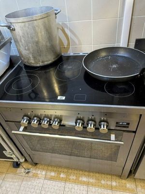 pots and pans are on the stove top of a stainless steel stove