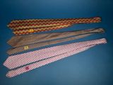 four ties are lined up on a blue surface