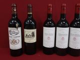 six bouteilles de vin sont alignées sur une surface rouge
