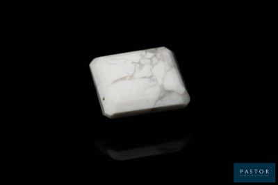 un bloc de marbre blanc posé sur une surface noire