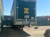 two semi trucks parked in a parking lot next to each other