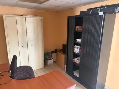 un bureau avec une chaise et une armoire dans une pièce