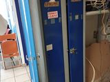 two blue lockers in a room with a lot of wires on the wall