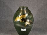 a green vase with gold fish in it on a gray background