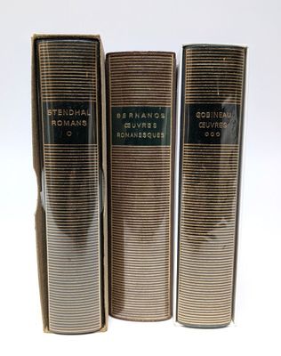 trois livres superposés sur une surface blanche