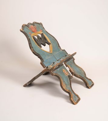 une vieille chaise en bois sur laquelle est peint un homme assis