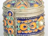 une boîte argentée ornée d'un motif orange et bleu