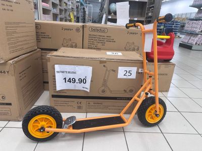 un scooter posé par terre devant des cartons