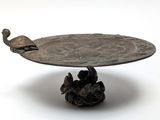 a metal tray with a bird on top of it