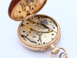 a gold pocket watch with a chain attached to it