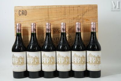 six bouteilles de vin rouge sont alignées devant une caisse en bois