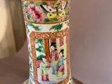 a vase with a painting on it sitting on a table