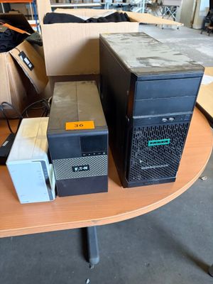 trois ordinateurs posés sur une table dans une pièce