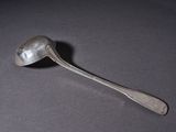 silver spoon with a spoon handle sitting on a table