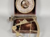 une boussole ancienne plaquée laiton, accompagnée d'un coffret en bois et d'une poignée en métal