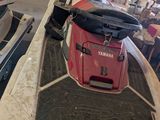 a red and white boat and a red and black boat in a garage