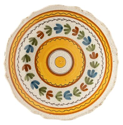 an overhead view of a yellow and blue bowl with leaves on it
