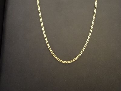 un collier à chaîne en or avec un maillon sur fond noir