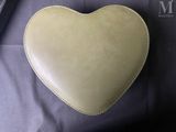 a heart shaped bag sitting on top of a black bag