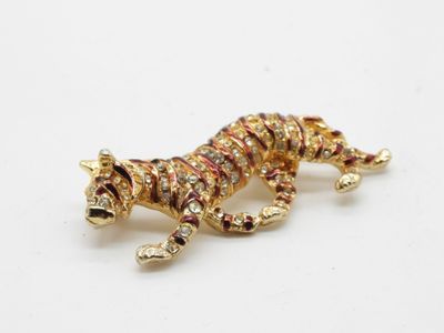 un gros plan d'une broche en forme de tigre posée sur une surface blanche