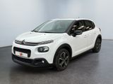 une voiture blanche de marque Citrole garée dans une pièce blanche