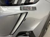the front end of a silver car with a sticker on it