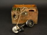 a wooden box with a telephone and a cord in it