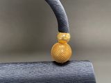 a close up of a yellow bead on top of a blue fabric