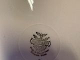 a close up of a white plate with a gold emblem on it