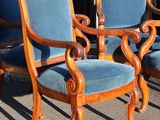 three blue chairs sitting next to each other in front of a building