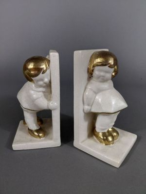 une paire de figurines blanches et dorées représentant un garçon et une fille