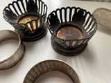 two silver bowls and two silver bangles on a table