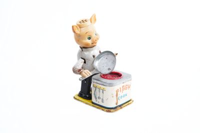 une figurine représentant un chef aux fourneaux avec une poêle