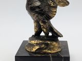 a black and gold statue of a bird on a marble base