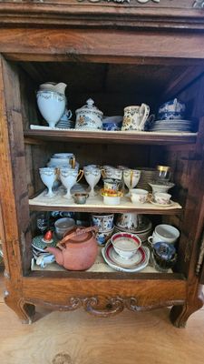 un meuble en bois sur lequel sont disposées de nombreuses tasses et soucoupes
