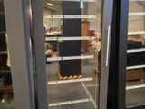 two refrigerators that are sitting side by side in a warehouse
