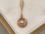 an image of a gold plated pendant with a green stone