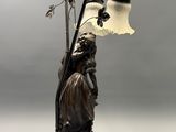 statue of a woman holding a lamp and a lamp shade