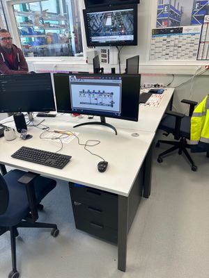 une photo d'un bureau avec deux écrans et un clavier