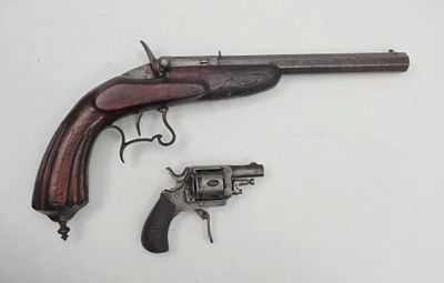 un gros plan d'un pistolet et d'un revolver posés sur une surface blanche