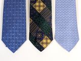three different colored ties hanging on a wall in a row