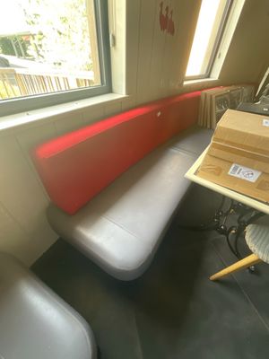un banc rouge et blanc dans un coin de la pièce