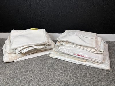 deux sacs en tissu blanc posés par terre l'un à côté de l'autre