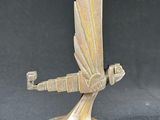 an image of a bronze statue of a flying bird on a black background
