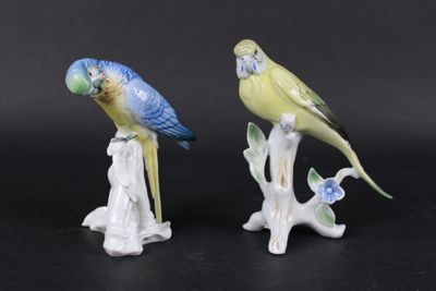 deux figurines représentant des oiseaux perchés sur une branche d'arbre