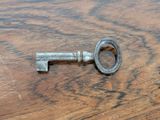 an old key sitting on a wooden table