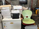 un tas d'appareils électroménagers et une chaise dans un entrepôt