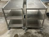 two stainless steel tables on wheels in a room