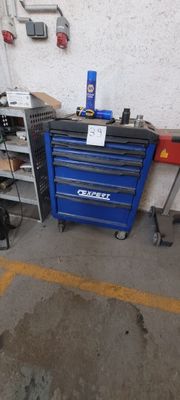 un garage avec un coffre à outils bleu et une boîte à outils rouge